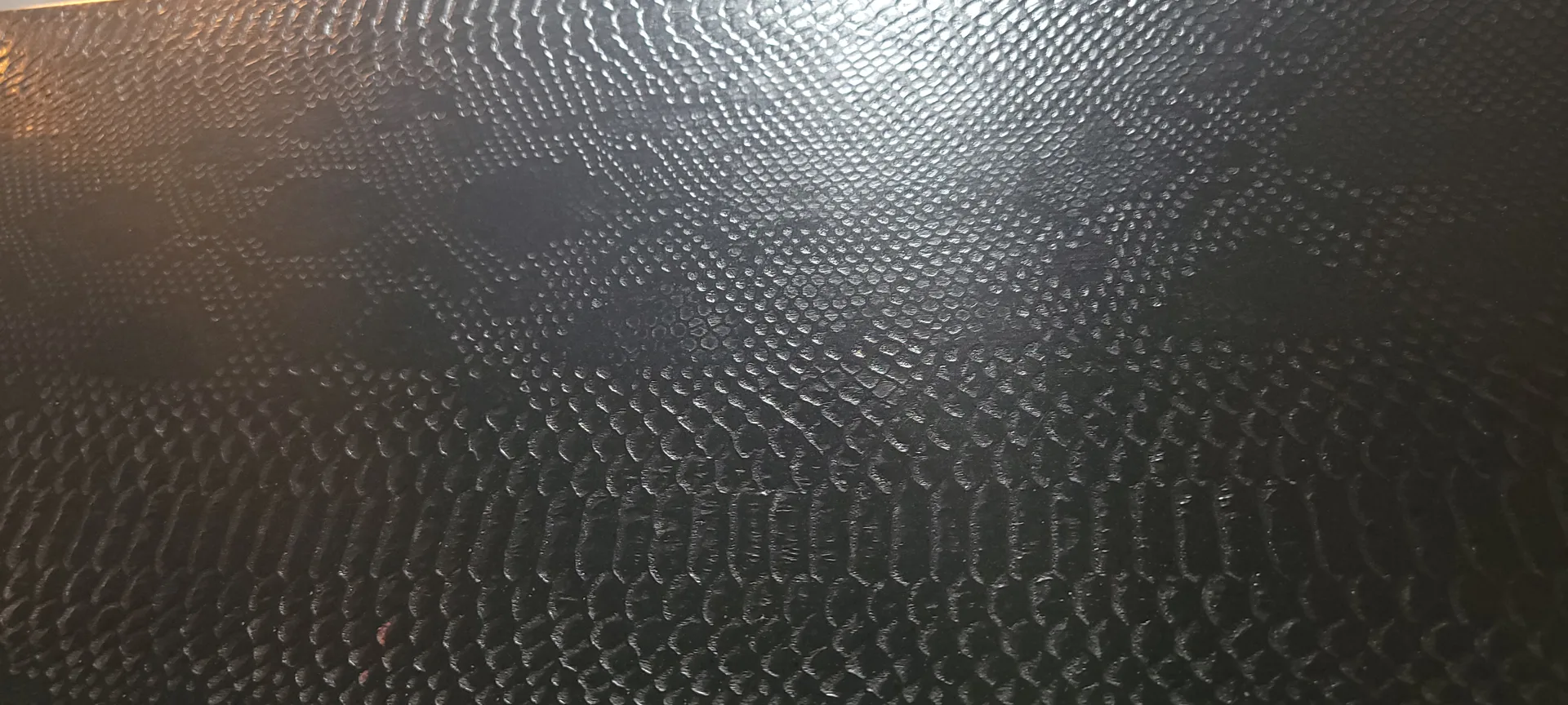 Close-up of textured metal surface with diamond plate pattern and reflective highlights