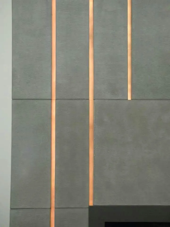 Gray tile wall with three vertical orange LED light strips creating geometric divisions across the surface