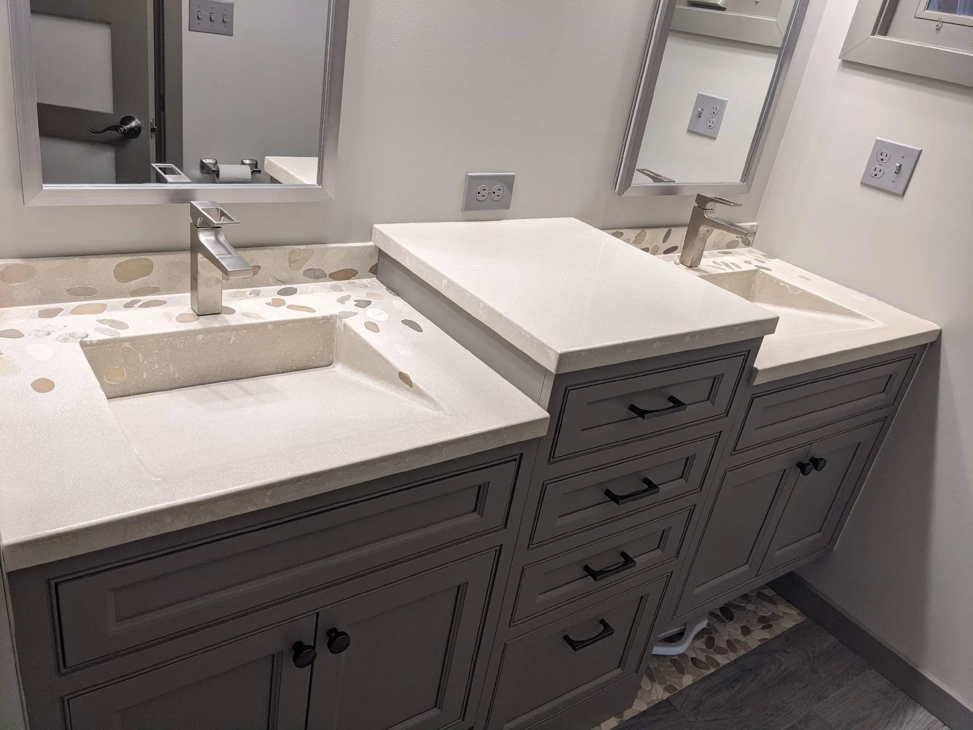 Modern bathroom vanity with dual sinks, white quartz countertop with stone pattern, dark gray cabinetry, chrome faucets, and framed mirrors above each sink