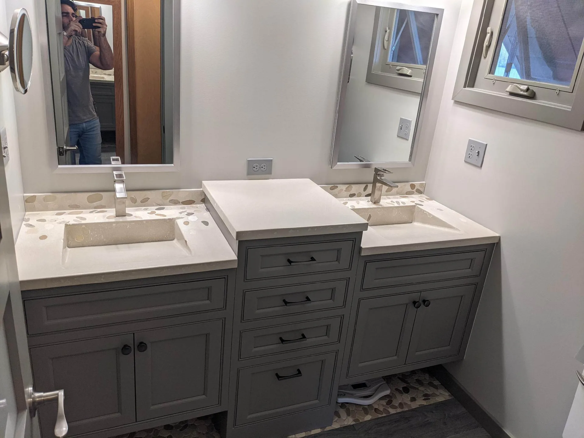 Modern bathroom vanity with dual sinks, white countertop, gray cabinetry, and dual mirrors in Cincinnati home