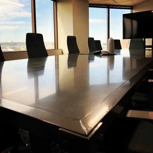 Modern high-rise conference room with polished white table, black chairs, and panoramic city views of Cincinnati, Ohio skyline
