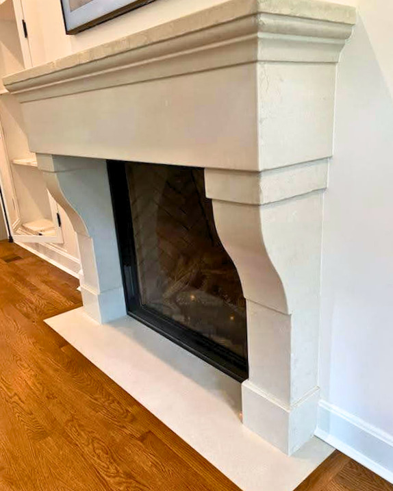 White fireplace mantel with black fireplace insert on hardwood floor in modern home interior